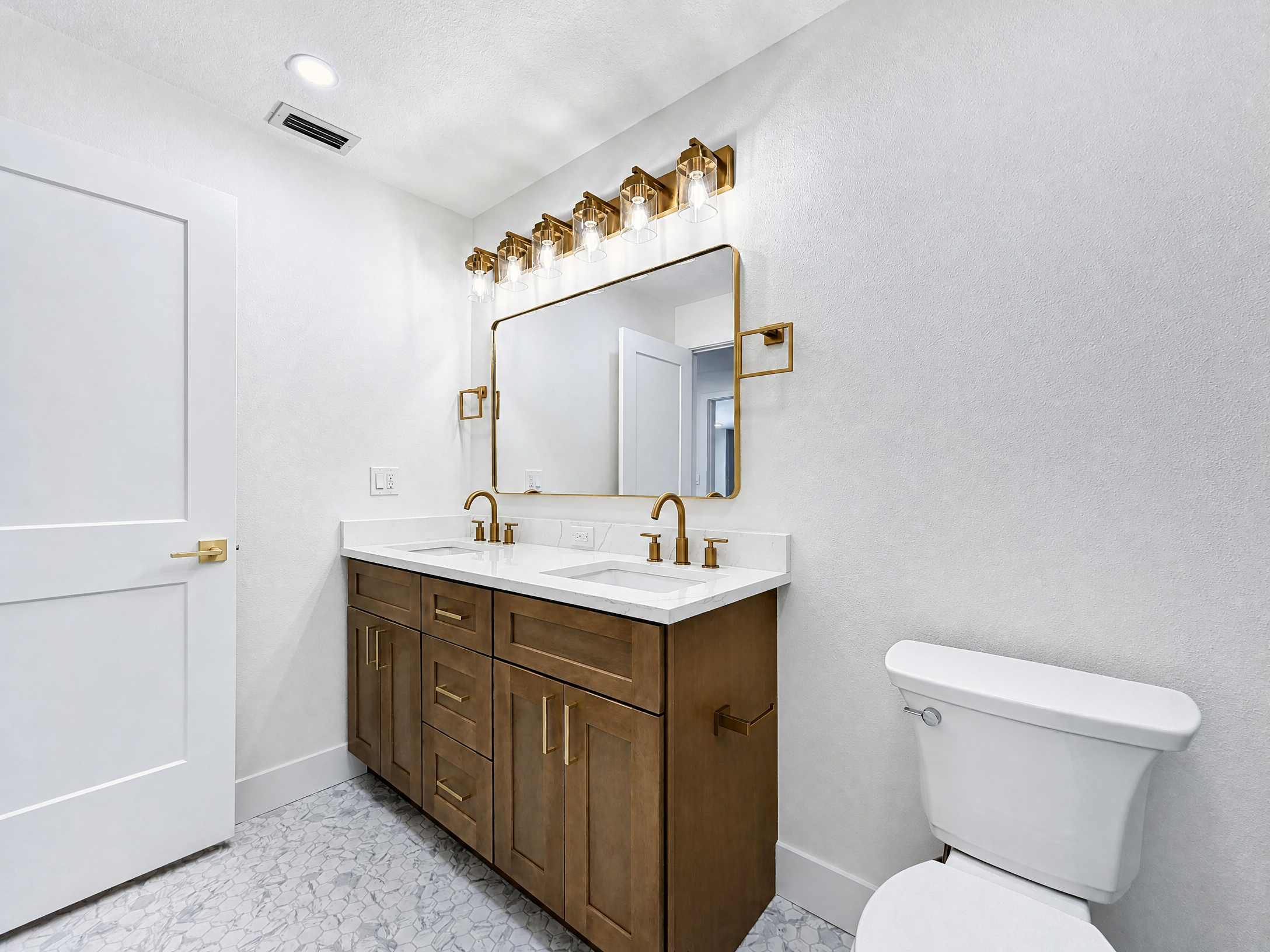 Tampa Bay bathroom remodeling project — Belleair walnut double vanity with brass sconces