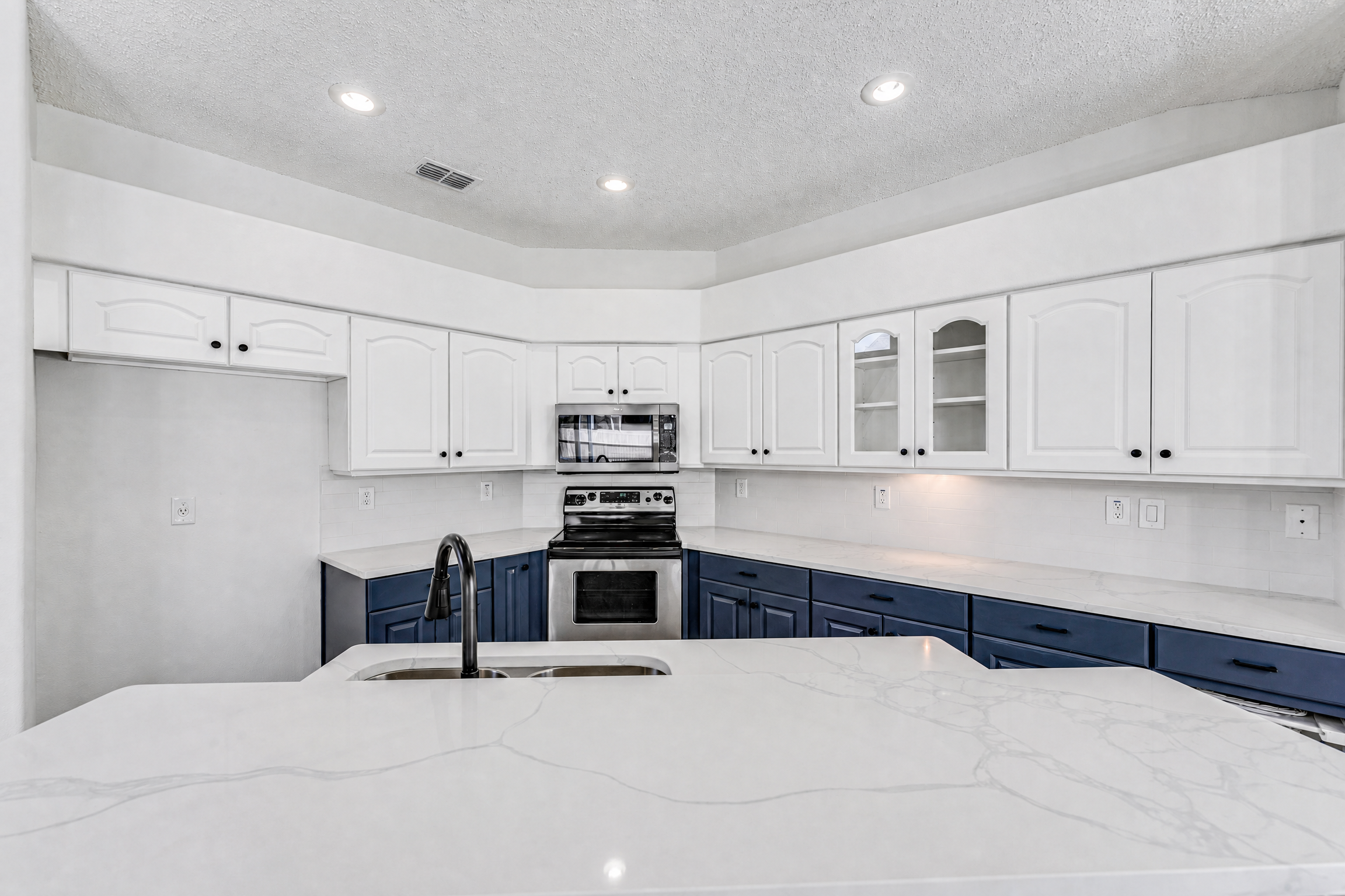 Tampa Bay cabinet refinishing project — White and navy refinished kitchen cabinetry