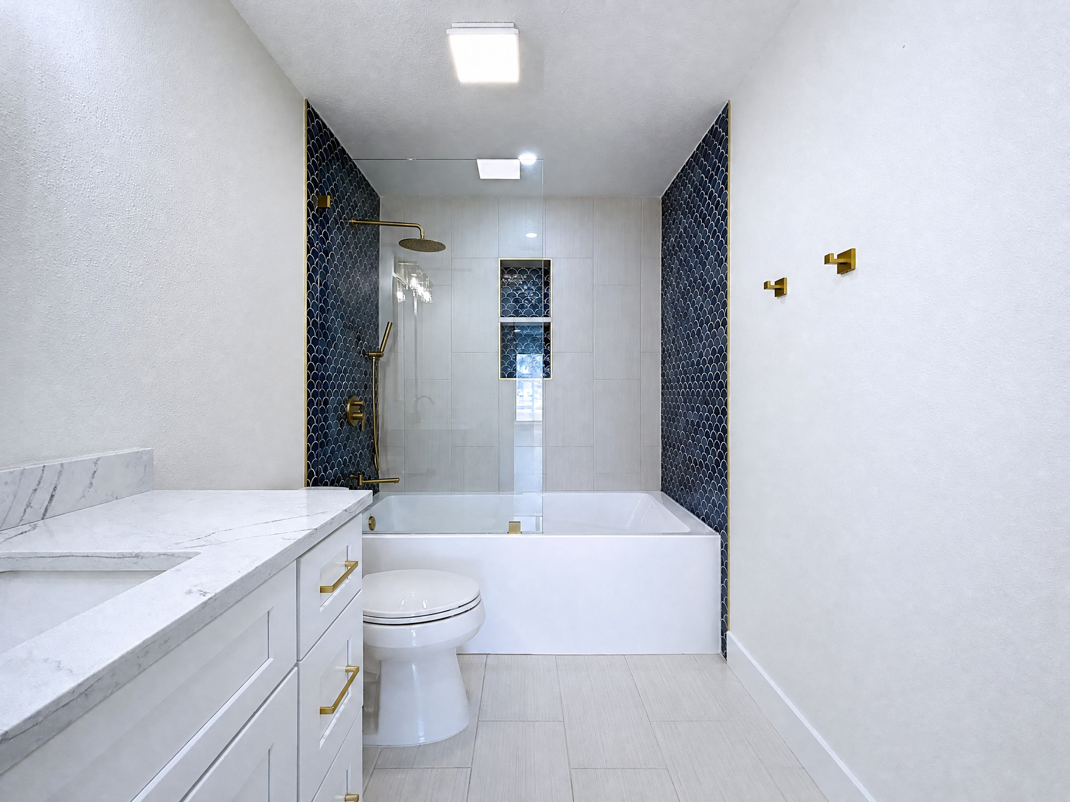 Tampa Bay bathroom remodeling project — Belleair white and brass bathroom with freestanding tub
