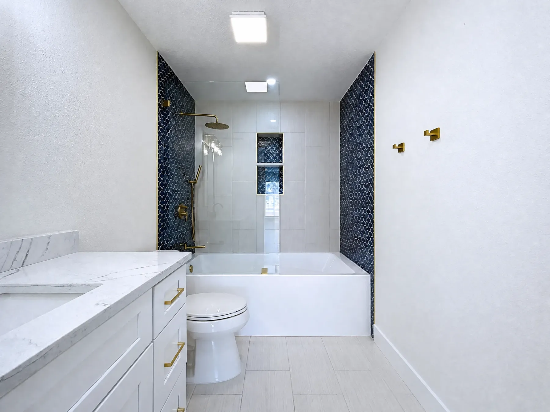 Tampa Bay bathroom remodeling project — Belleair white and brass bathroom with freestanding tub