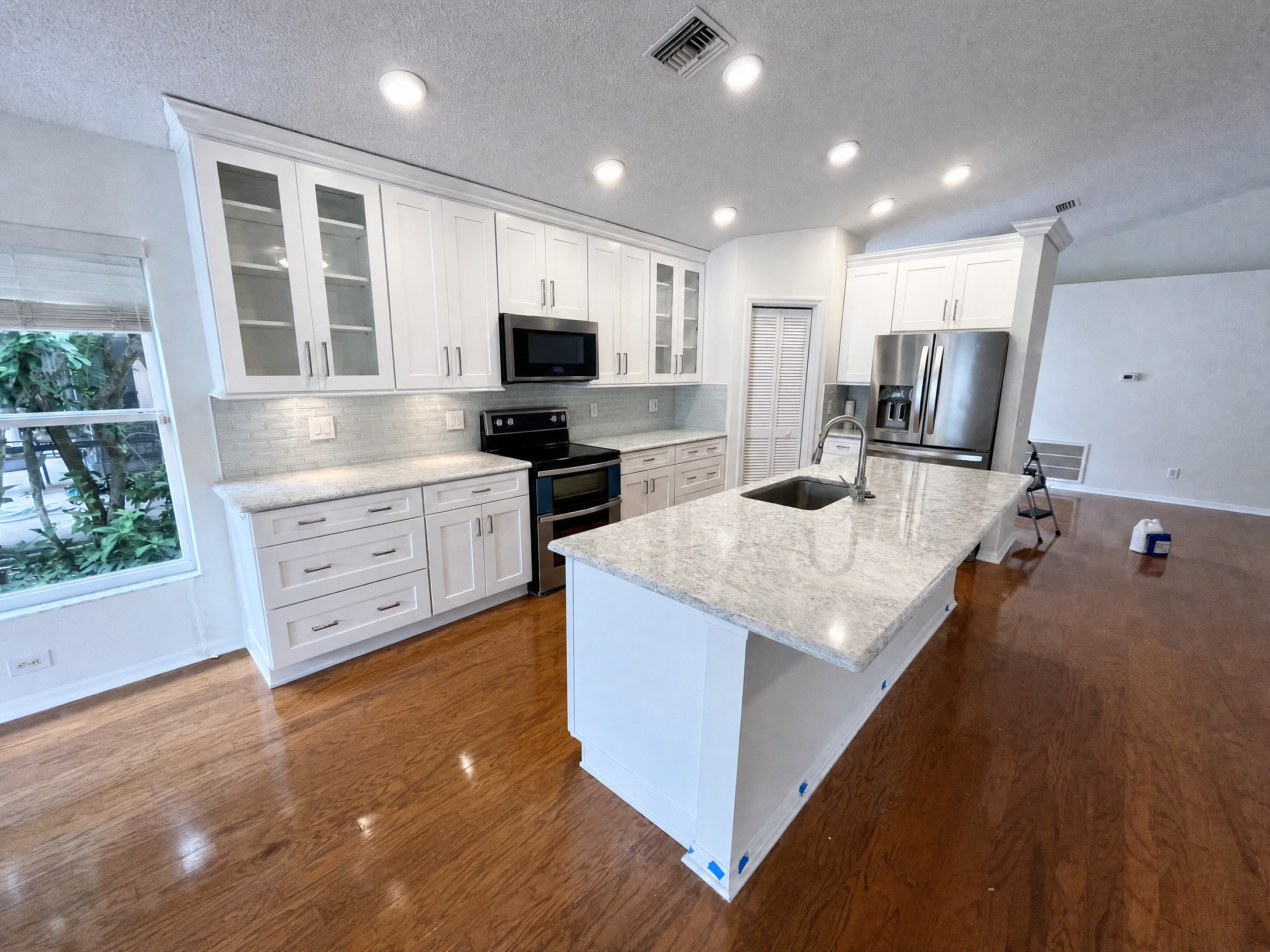 Tampa Bay cabinet refinishing project — Refinished white shaker kitchen with glass doors