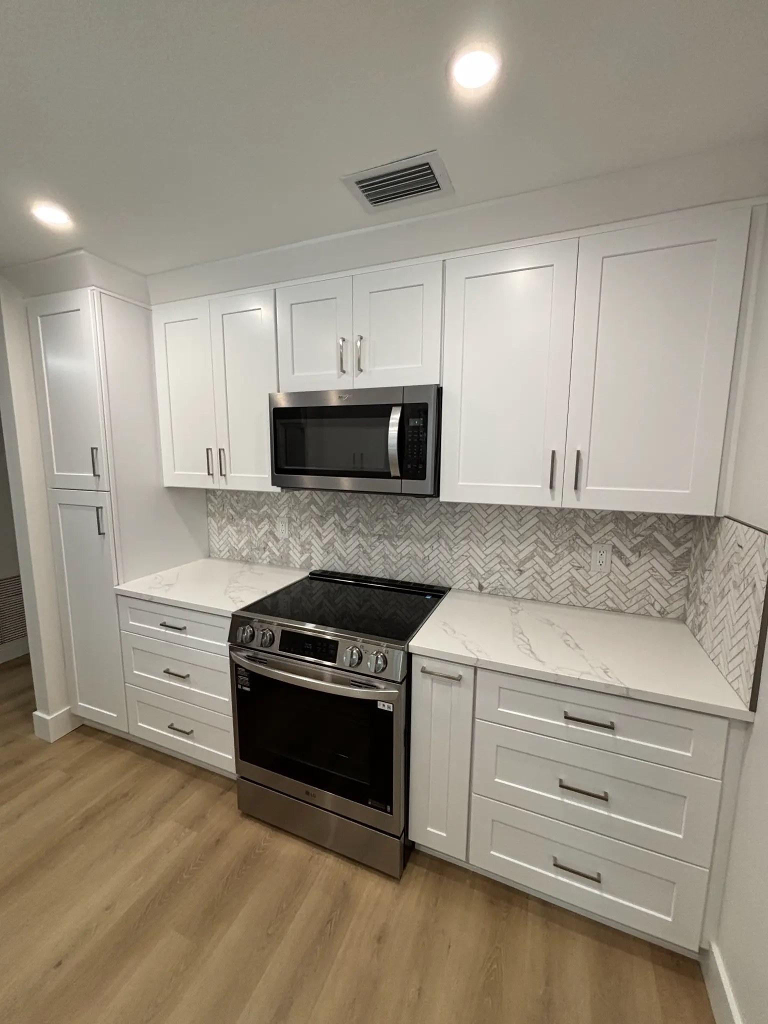 Tampa Bay kitchen remodeling — white shaker kitchen with chevron tile backsplash
