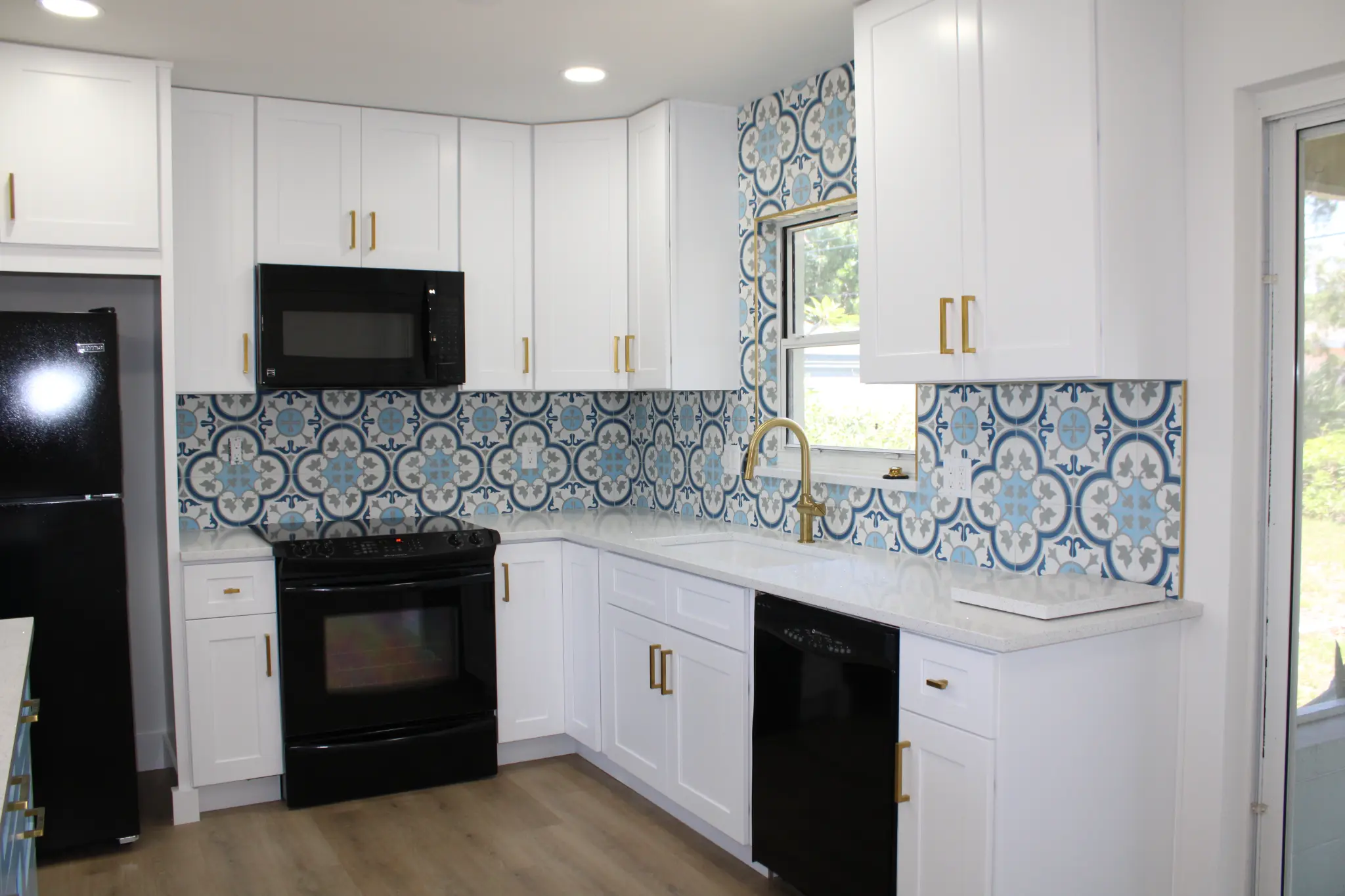 Tampa Bay kitchen remodeling — white shaker kitchen with custom aqua island and gold fixtures