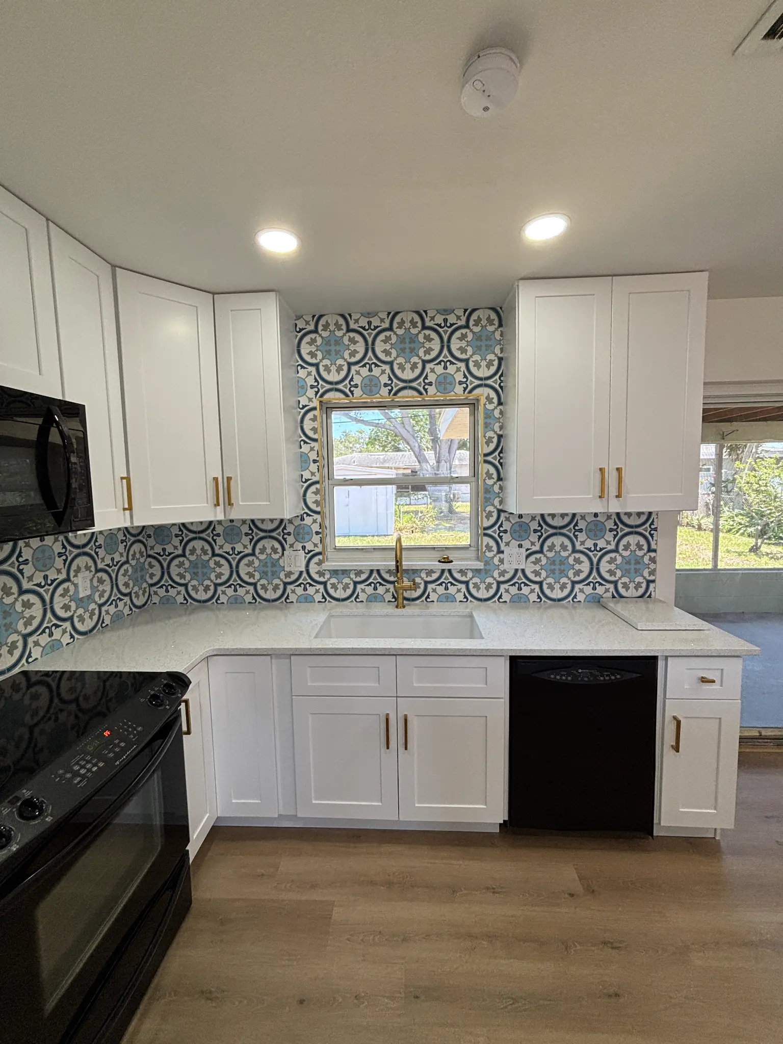 Tampa Bay kitchen remodeling — white shaker kitchen with custom aqua island and gold fixtures