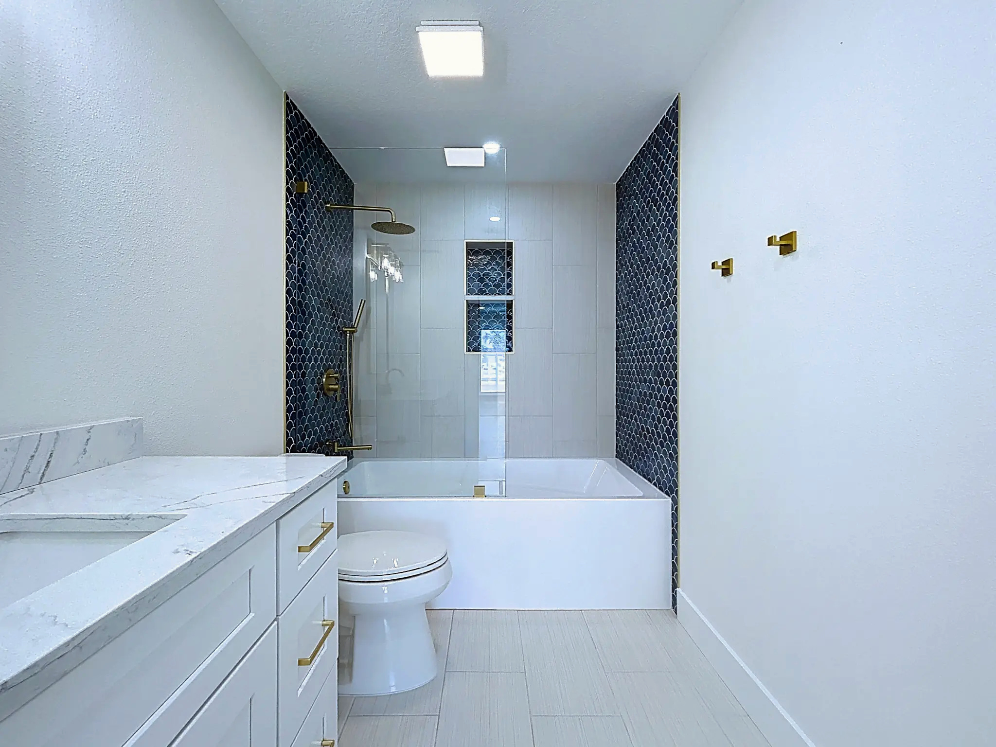 Bathroom remodeling in Tampa Bay — Belleair bathroom with white brass tub and scallop tile