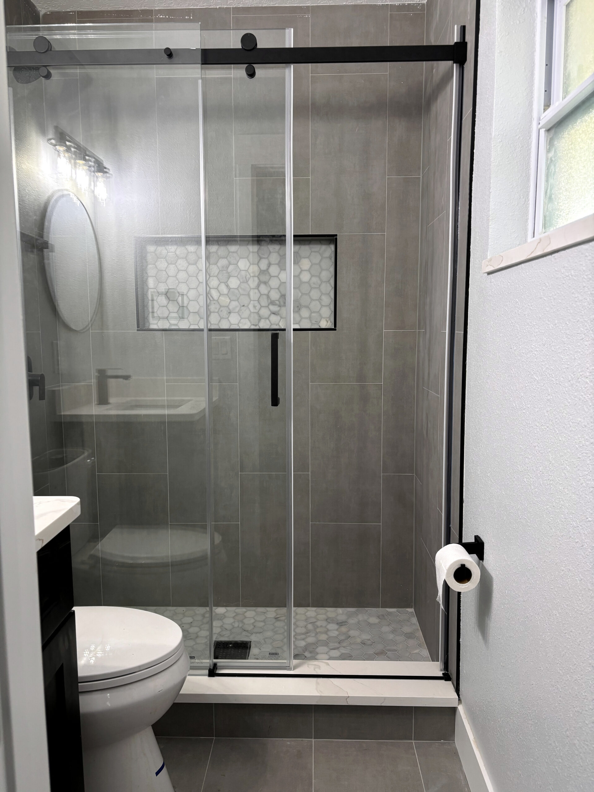 Bathroom remodeling in Tampa Bay — Grey tile shower with black fixtures