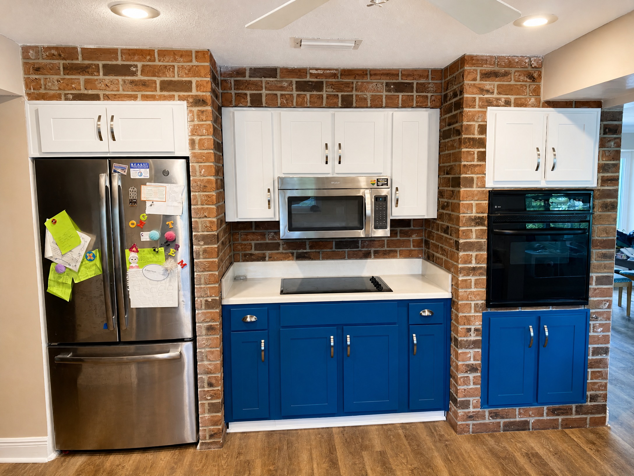 Two-tone white and royal blue cabinet refacing kitchen with brick range wall
