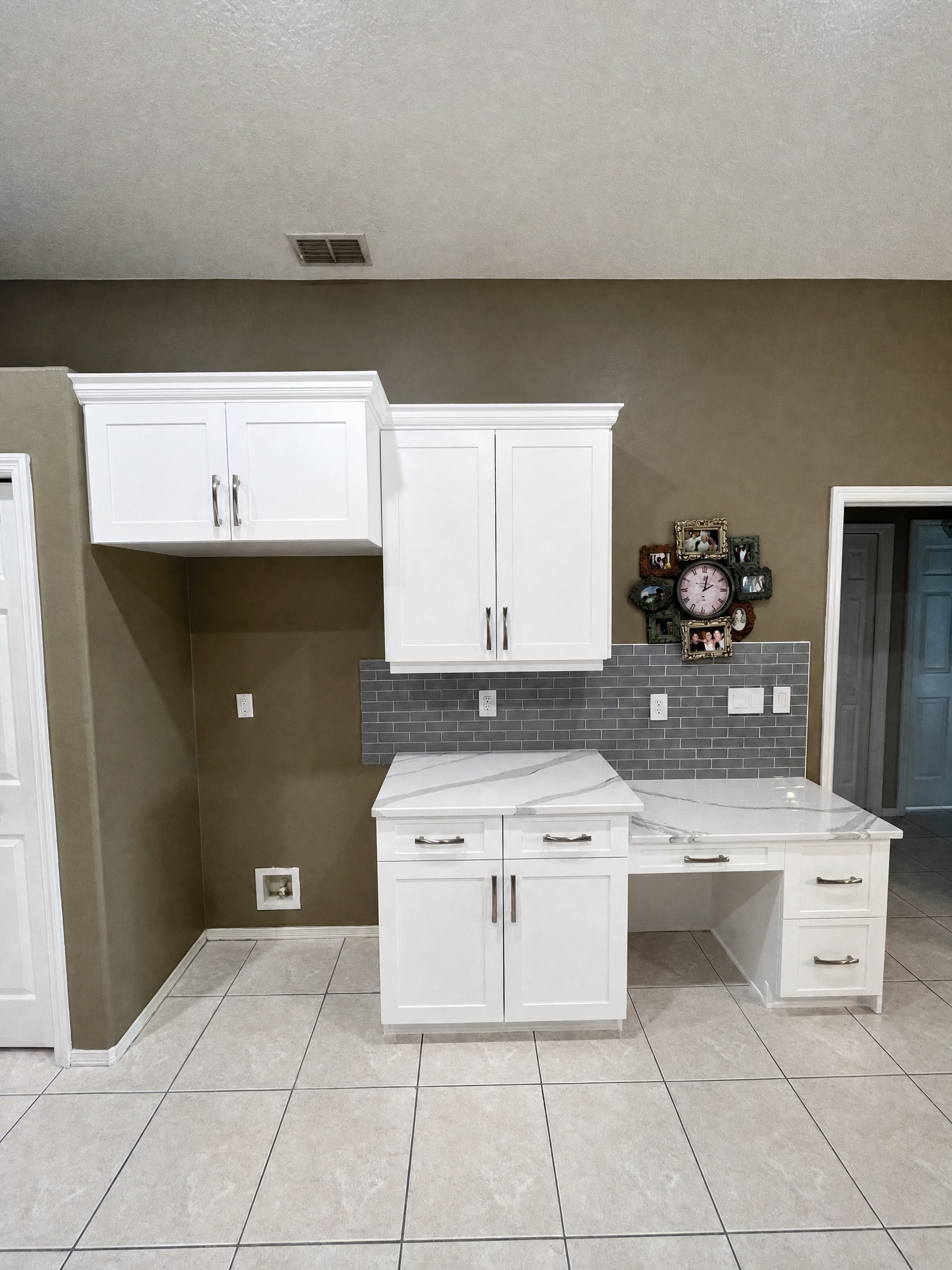 White shaker cabinet refacing with built-in desk and gray subway tile