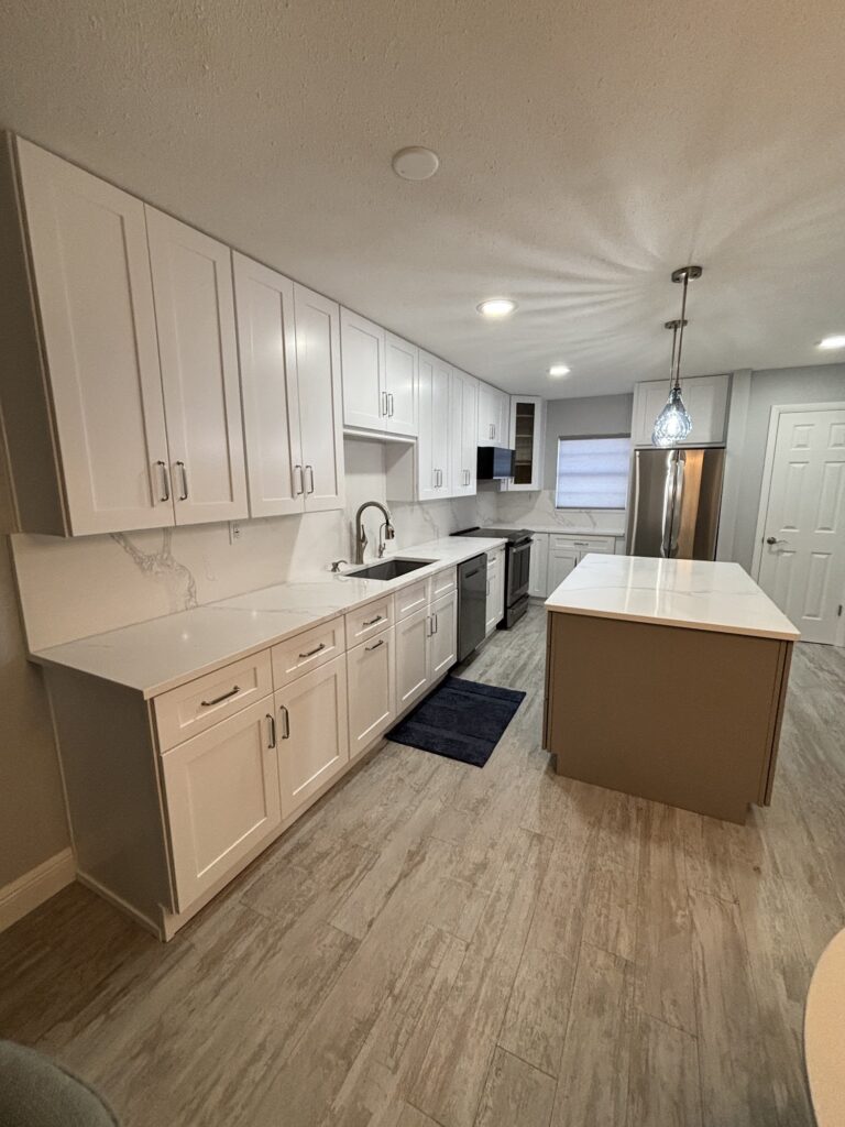 White shaker kitchen with an island and wood-look floors, Tampa Bay kitchen remodel