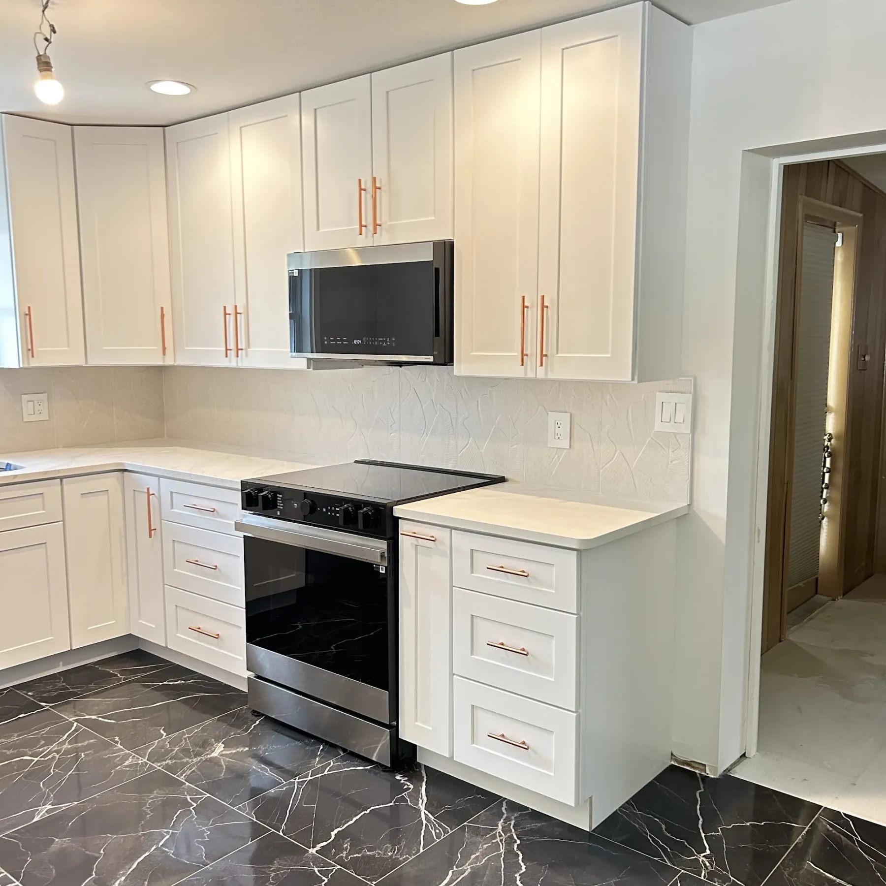 Remodeled white shaker kitchen with copper pulls and a textured backsplash, Tampa Bay
